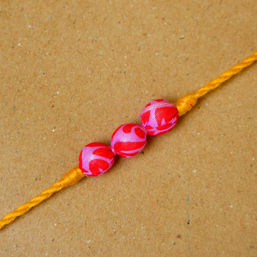 Handmade Pink & Yellow Potli Upcycled Fabric Rakhi With Roli Chawal