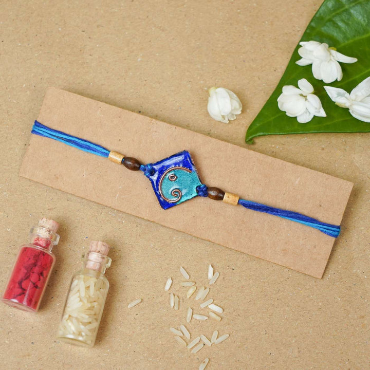 Handmade Square Ganesh Copper Enamel Rakhi With Chocolates & Roli Chawal