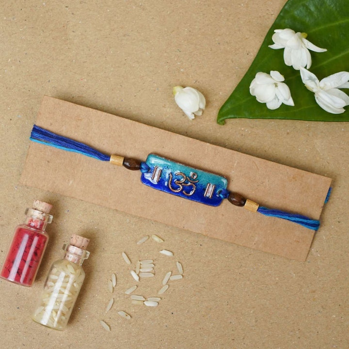 Handmade Rectangle Om Copper Enamel Rakhi With Chocolates & Roli Chawal