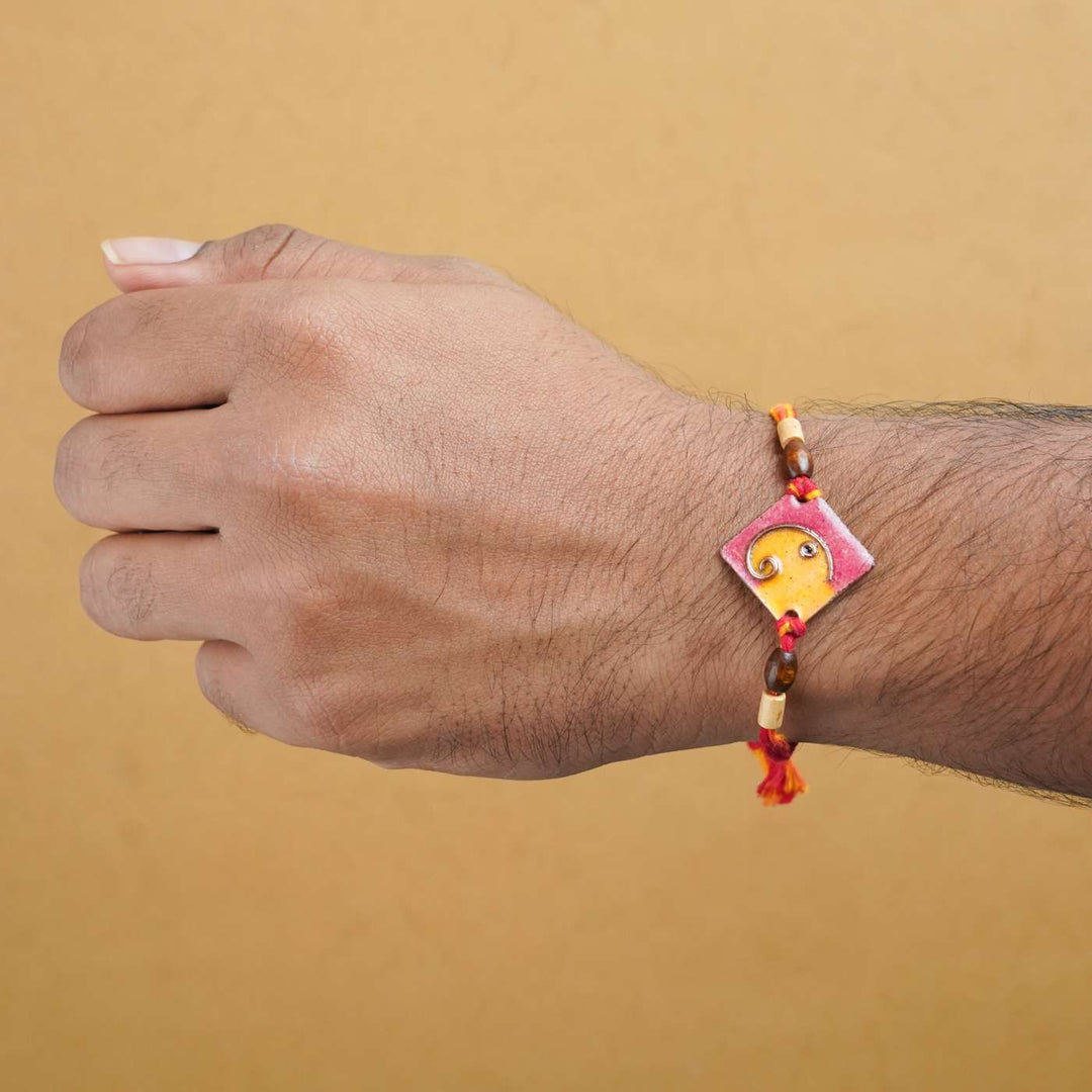 Handmade Square Ganesh Copper Enamel Rakhi With Chocolates & Roli Chawal