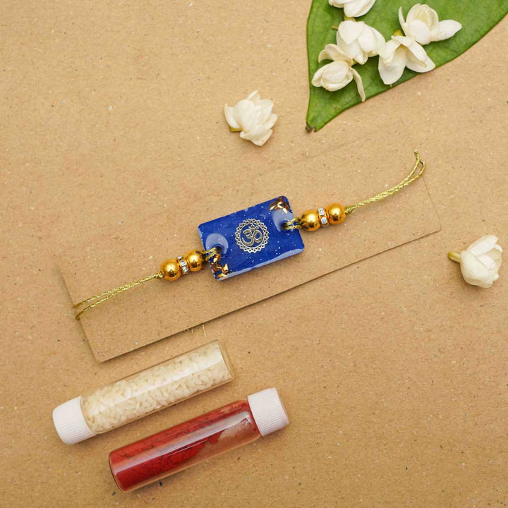 Handmade Resin Rectangle Blue Om Rakhi With Roli Chawal